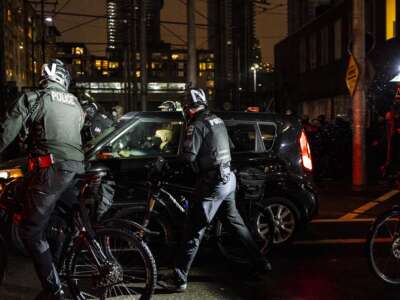 Police surround a car driven by a member of a car brigade at a racial justice protest on November 3, 2020 in Seattle, Washington.