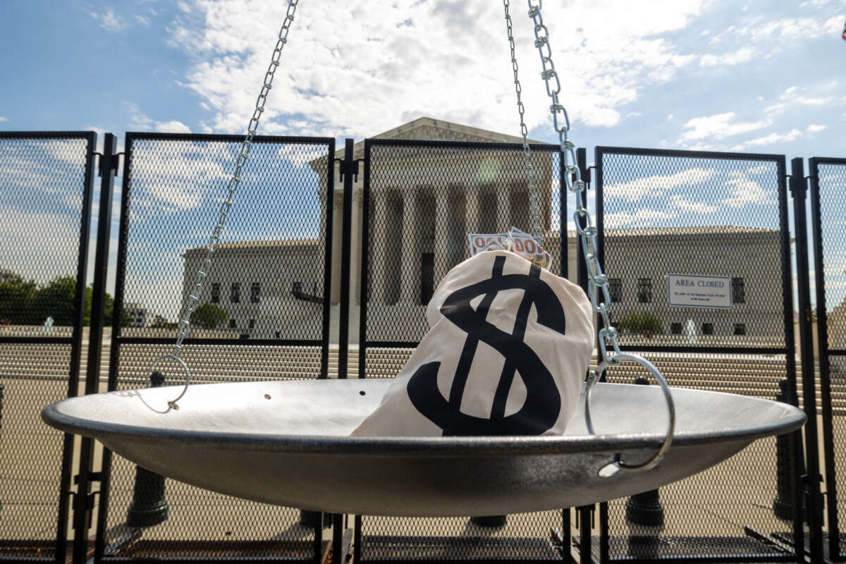A mock bag of money is seen on a scale outside the Supreme Court building ahead of the delivery of a petition demanding the impeachment of Justice Clarence Thomas on July 28, 2022, in Washington, D.C.
