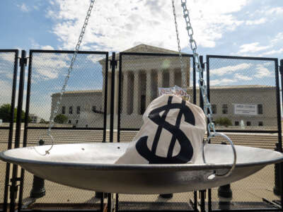 A mock bag of money is seen on a scale outside the Supreme Court building ahead of the delivery of a petition demanding the impeachment of Justice Clarence Thomas on July 28, 2022, in Washington, D.C.