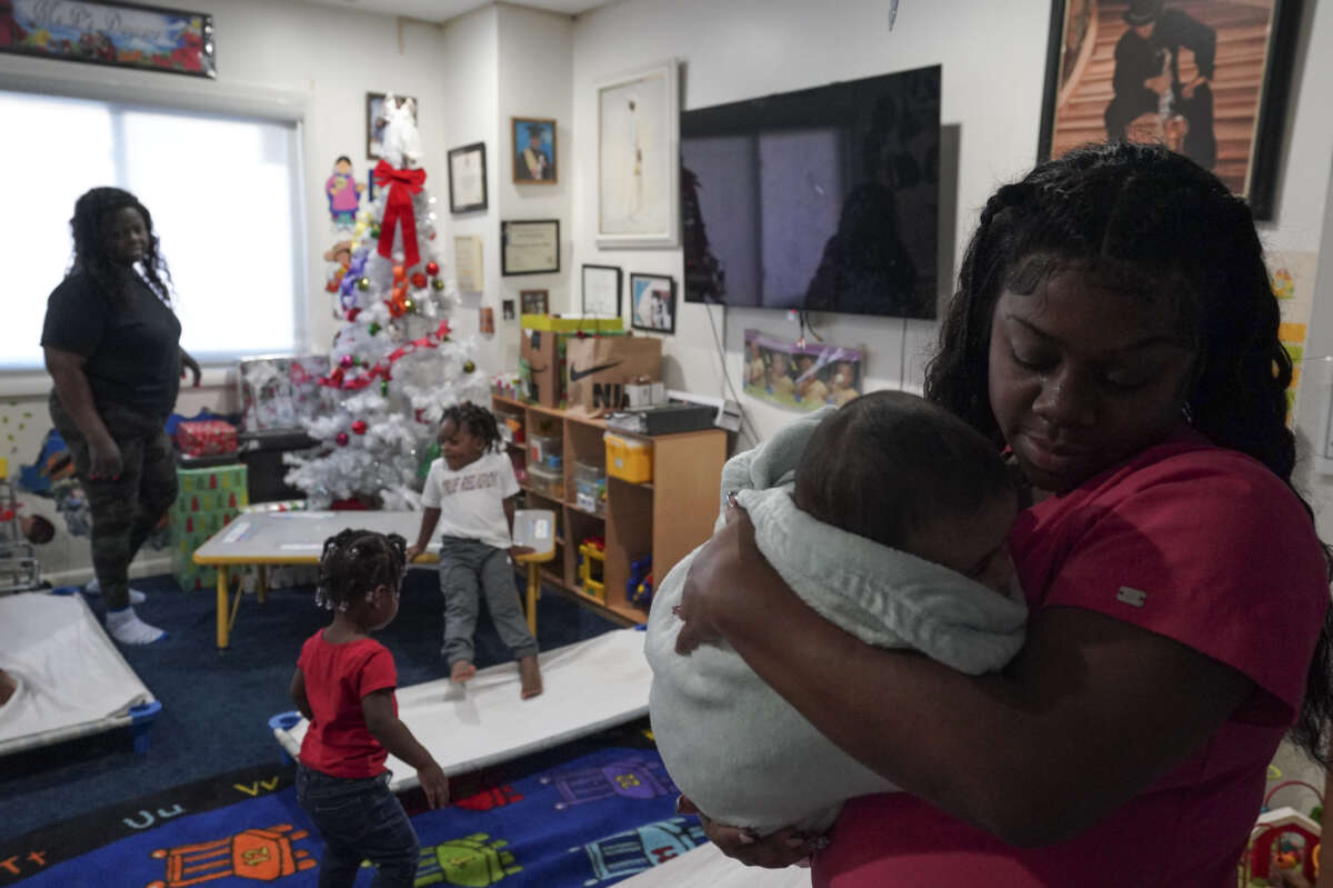 Takia Bridgeforth, lead teacher at Ms. Ps Child and Family Services, comforts a baby on December 20, 2022 in Washington, D.C.