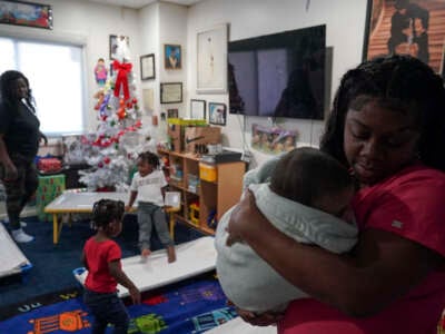 Takia Bridgeforth, lead teacher at Ms. Ps Child and Family Services, comforts a baby on December 20, 2022 in Washington, D.C.