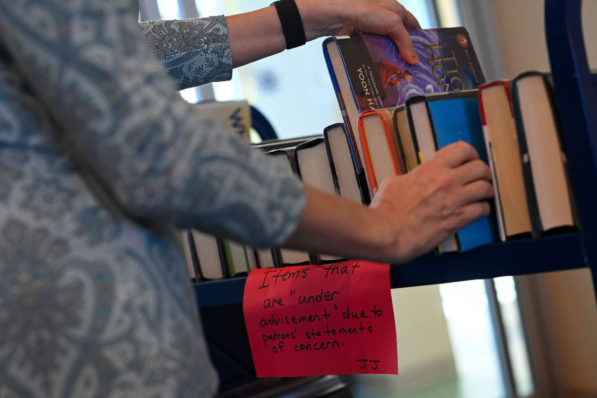 St. Tammany Parish Library Director Kelly LaRocca pulls from a cart of books that were removed from the shelves at the Peter L. "Pete" Gitz Library on February 13, 2023, in Madisonville, Louisiana.