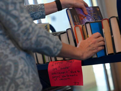 St. Tammany Parish Library Director Kelly LaRocca pulls from a cart of books that were removed from the shelves at the Peter L. "Pete" Gitz Library on February 13, 2023, in Madisonville, Louisiana.