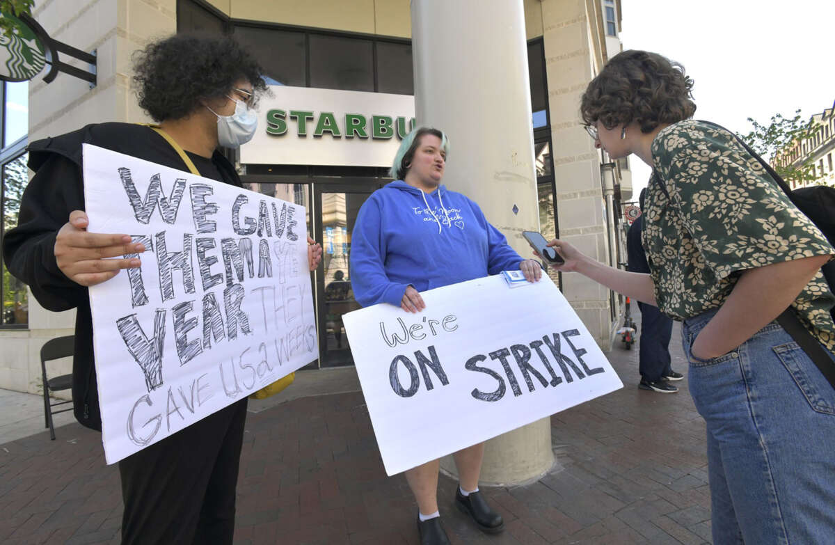 Mizzy Pareidolia (left) and Alex Boyd (center) hold strike signs outside Starbucks on North Charles Street in Mount Vernon, Baltimore.