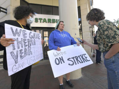 Mizzy Pareidolia (left) and Alex Boyd (center) hold strike signs outside Starbucks on North Charles Street in Mount Vernon, Baltimore.
