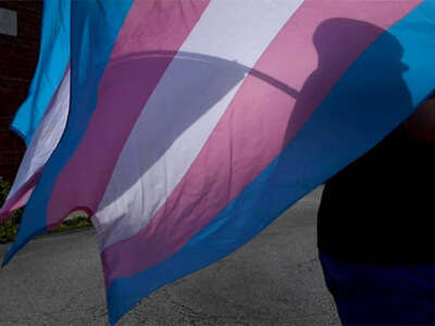 A marcher carries a Transgender Pride flag during a march in Kansas City, Missouri.
