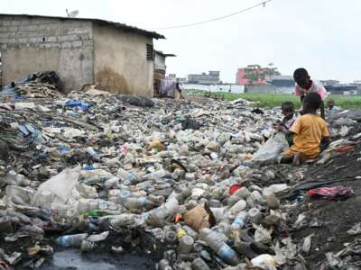 Children play amid discarded plastic bottles in Anyama, Côte d'Ivoire, on May 25, 2023.