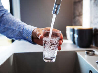 A man fills a glass with tap water