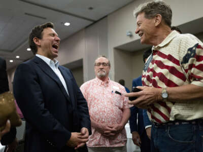 Florida Gov. Ron DeSantis (L) speaks with attendees during an Iowa GOP reception on May 13, 2023 in Cedar Rapids, Iowa.