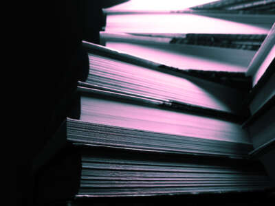 Stack of books in darkness lit with pink and blue light