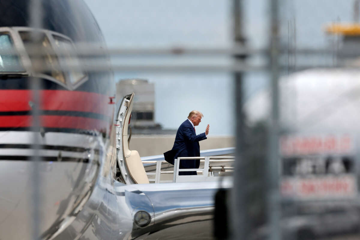 Former President Donald Trump waves as he arrives at the Miami International Airport on June 12, 2023, in Miami, Florida.