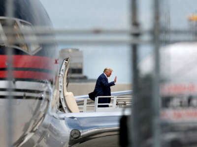 Former President Donald Trump waves as he arrives at the Miami International Airport on June 12, 2023, in Miami, Florida.