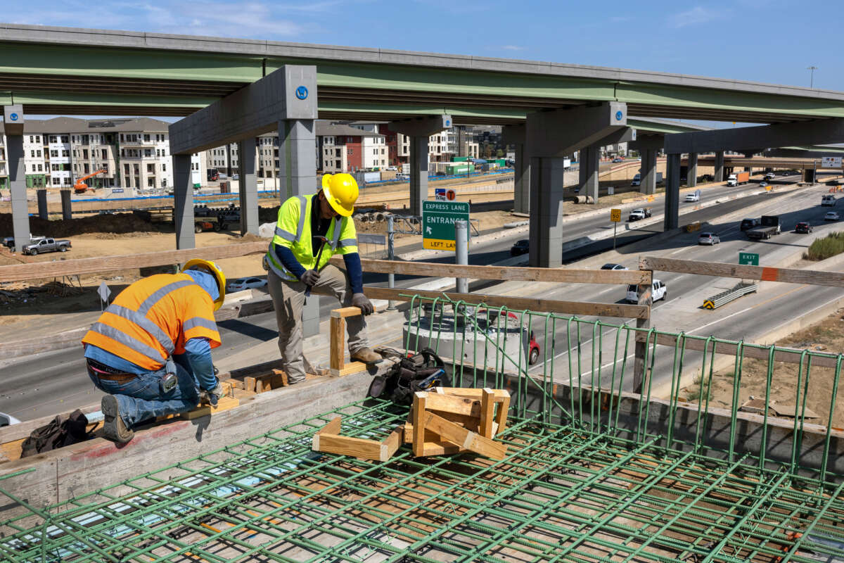 Workers construct an overpass as part of the Irving Interchange infrastructure project near the site of the former Dallas Cowboys Stadium on August 10, 2022, in Irving, Texas.