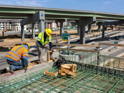 Workers construct an overpass as part of the Irving Interchange infrastructure project near the site of the former Dallas Cowboys Stadium on August 10, 2022, in Irving, Texas.