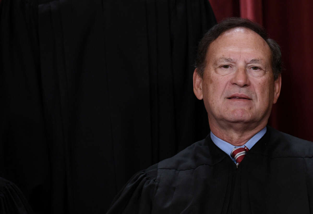 Justice Samuel Alito attempts to smile during a staff portrait