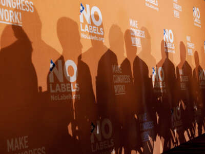 The shadows of several Democratic and Republican politicians are cast on a background during an event in Cannon Building hosted by No Labels to announce a congressional action plan on December 13, 2011.