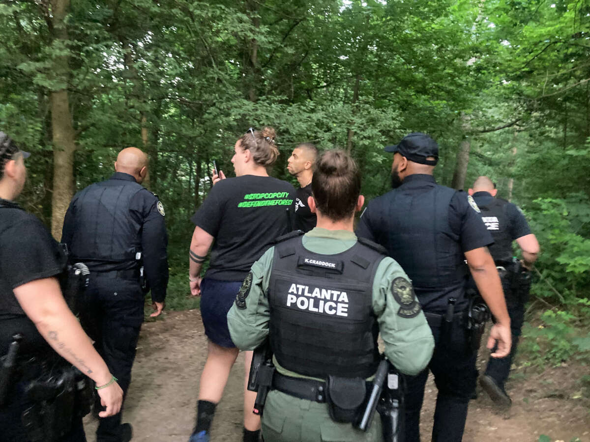 Over 20 police officers march through Brownwood Park on June 24, 2023, interrupting a scheduled vigil.