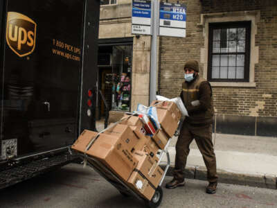 A UPS worker wearing a mask delivers packages in New York City