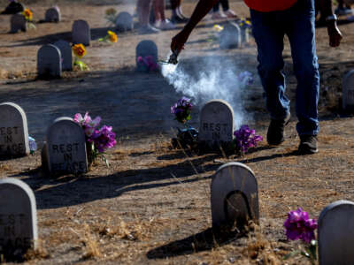 Dan Romero or Walking Bird of the Ute Tribe encircles the graves with sage smoke at Sherman Indian School Cemetery in Riverside, California, on Sunday, July, 18, 2021.