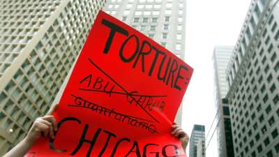 Adam Turl displays a sign protesting police torture during a demonstration on July 21, 2006 in downtown Chicago, Illinois.