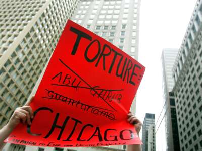 Adam Turl displays a sign protesting police torture during a demonstration on July 21, 2006 in downtown Chicago, Illinois.