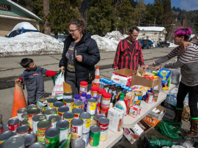People receive goods from an outdoor food pantry