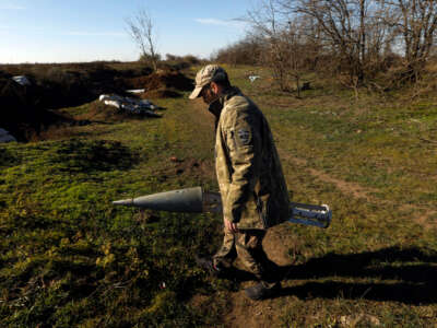 A member of the Ukrainian Special Forces holds a Russian missile cassette that carried cluster bombs, in Shyroke, Ukraine, on November 15, 2022.