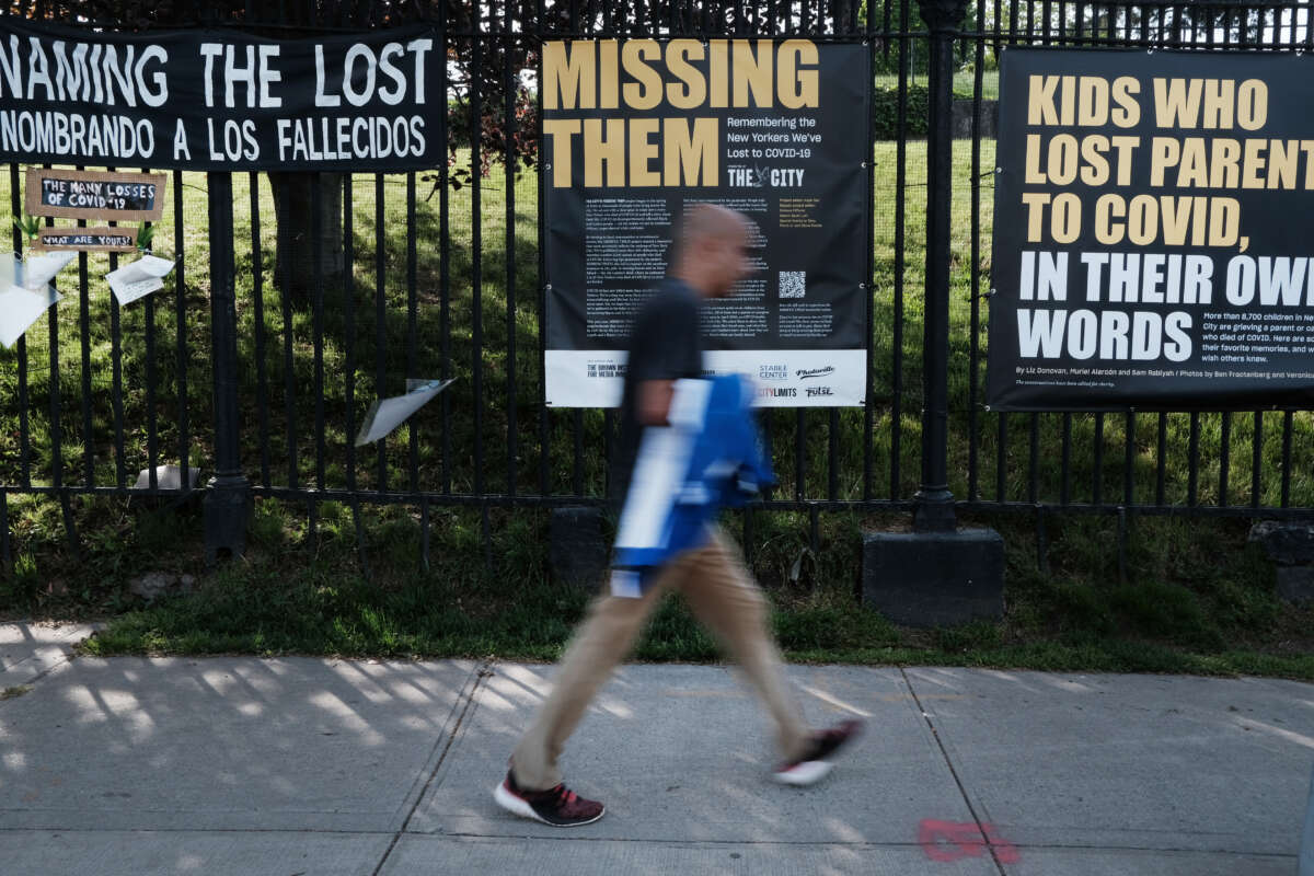 A person walks by tributes in art made by 20 community groups to those impacted by COVID-19, done in collaboration between Naming the Lost Memorials, City Lore and Green-Wood Cemetery, at Green-Wood Cemetery on May 8, 2023, in the Brooklyn borough of New York City.
