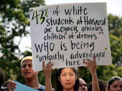 A Harvard student holds a sign during a rally protesting the Supreme Courts ruling against affirmative action on July 1, 2023, in Cambridge, Massachusetts.