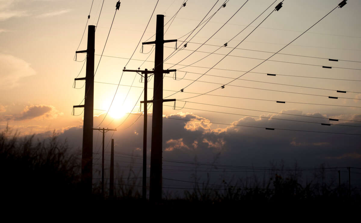 The sun sets behind power transmission lines in Texas on July 11, 2022.