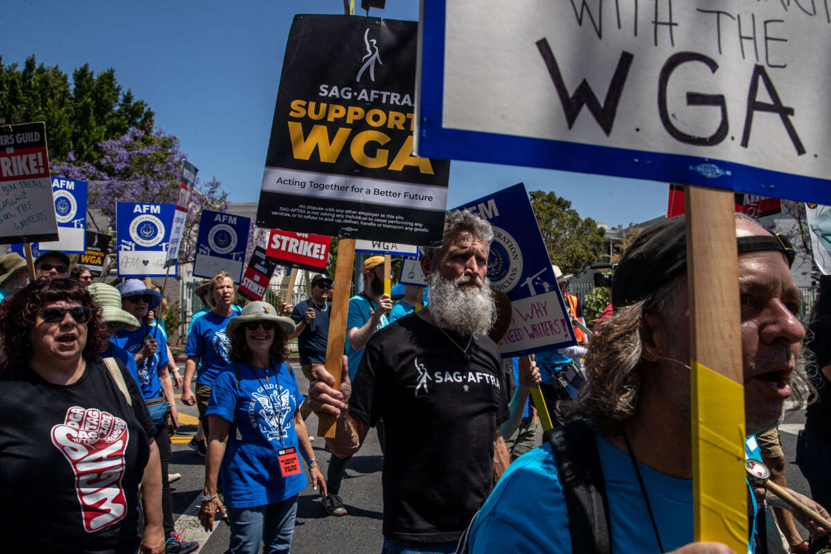 Actor John Tebbens, a member of SAG-AFTRA, marches in support of striking members of the Writers Guild of America during a rally at La Brea Tar Pits in Los Angeles, California.