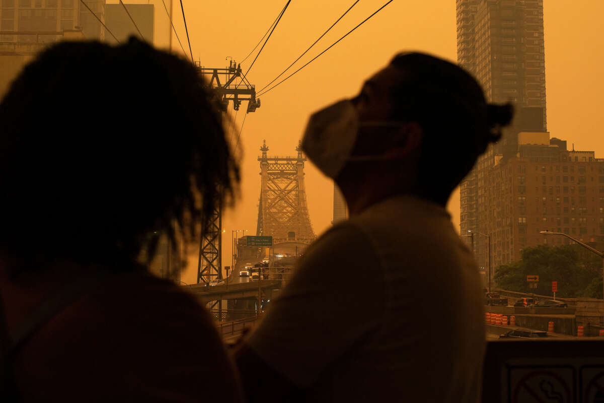 People wear masks as smoke from Canadian wildfires casts a haze over the area on June 7, 2023, in New York City.