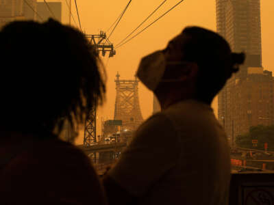 People wear masks as smoke from Canadian wildfires casts a haze over the area on June 7, 2023, in New York City.