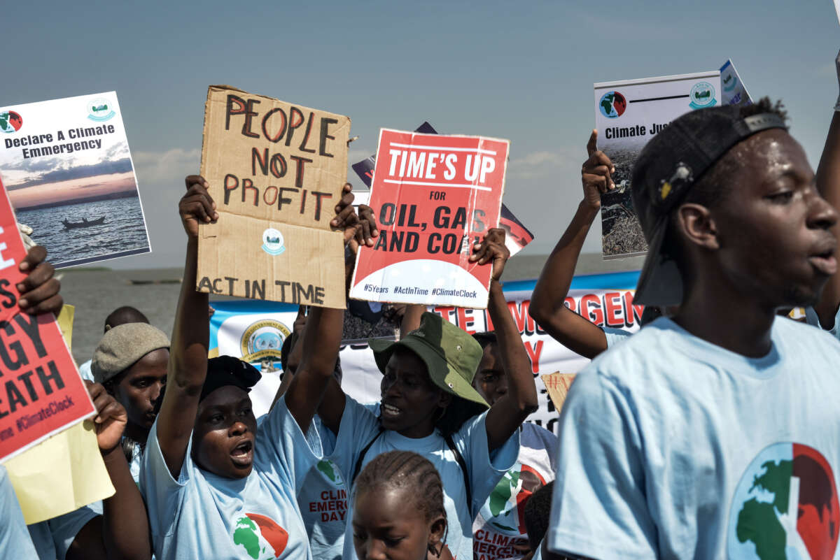 Environmental activists carry posters during a protest to demand for climate action for restoration of Lake Victoria as part of Climate Emergency Day 2023 on July 22, 2023, in Kisumu, Kenya.