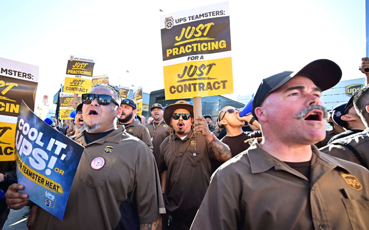 UPS workers hold placards at a rally held by the Teamsters Union on July 19, 2023, in Los Angeles, California, ahead of an August 1st deadline for an agreement on a labor contract deal and to avert a strike that could lead to billions of dollars in economic losses.