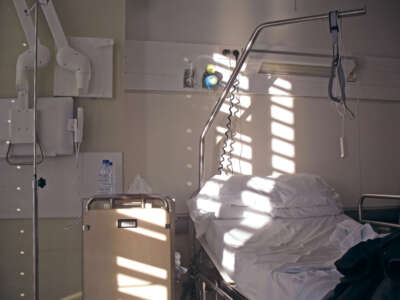 Empty hospital bed with bright day light coming through window blinds