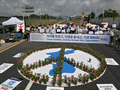 Antiwar activists hold a rally to mark the 70th anniversary of the signing of the Korean Armistice Agreement, near a military check point on the Tongil bridge along the road leading to the truce village of Panmunjom, in the border city of Paju, on July 27, 2023.