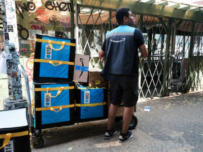 An Amazon worker moves boxes on July 11, 2023, in the East Village of New York City.