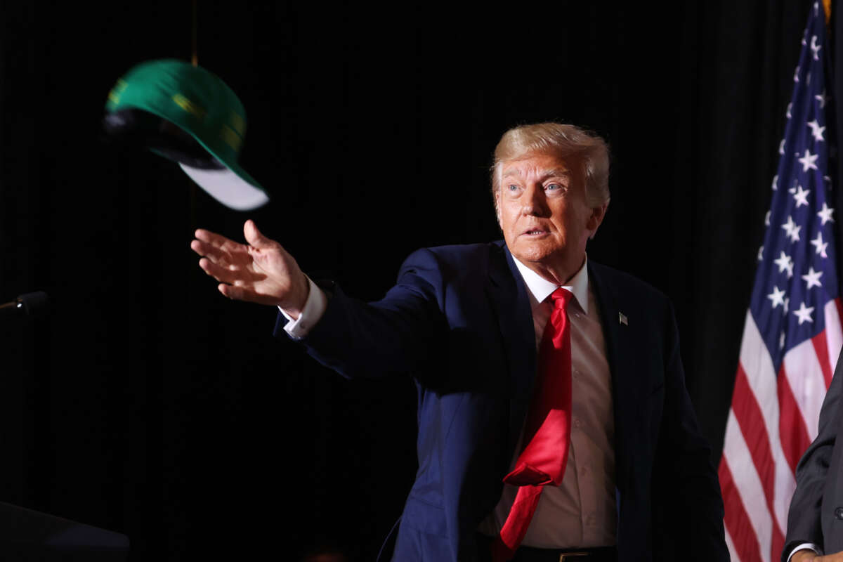 Former President Donald Trump tosses hats to supporters as he arrives for a Farmers for Trump campaign event at the MidAmerica Center on July 7, 2023, in Council Bluffs, Iowa.