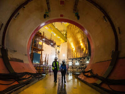 Workers walk in the reactor building equipment entry at the third-generation European Pressurised Reactor project (EPR) nuclear reactor of Flamanville, Normandy, on June 14, 2022.