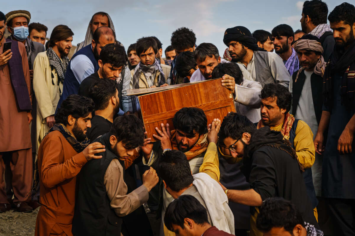 Caskets for the dead are carried towards the gravesite as relatives and friends attend a mass funeral for members of a family that were killed in a U.S. drone airstrike in Kabul, Afghanistan, on August 30, 2021.
