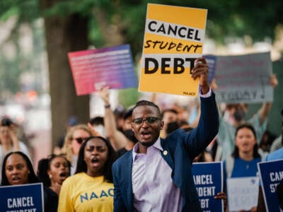 Activists outside the White House hold signs saying "Cancel Student Debt"