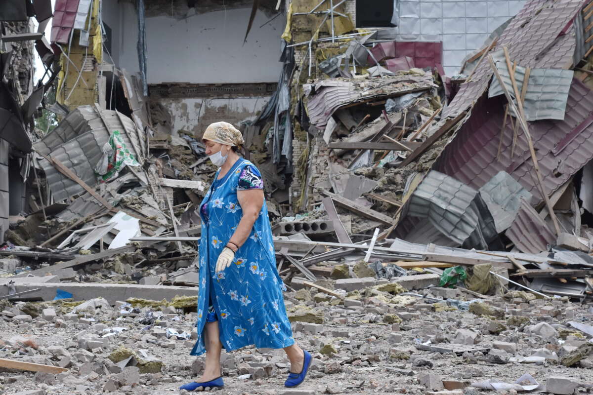 Ukraine resident walks by high school that was damaged by shelling