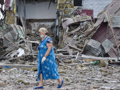 Ukraine resident walks by high school that was damaged by shelling