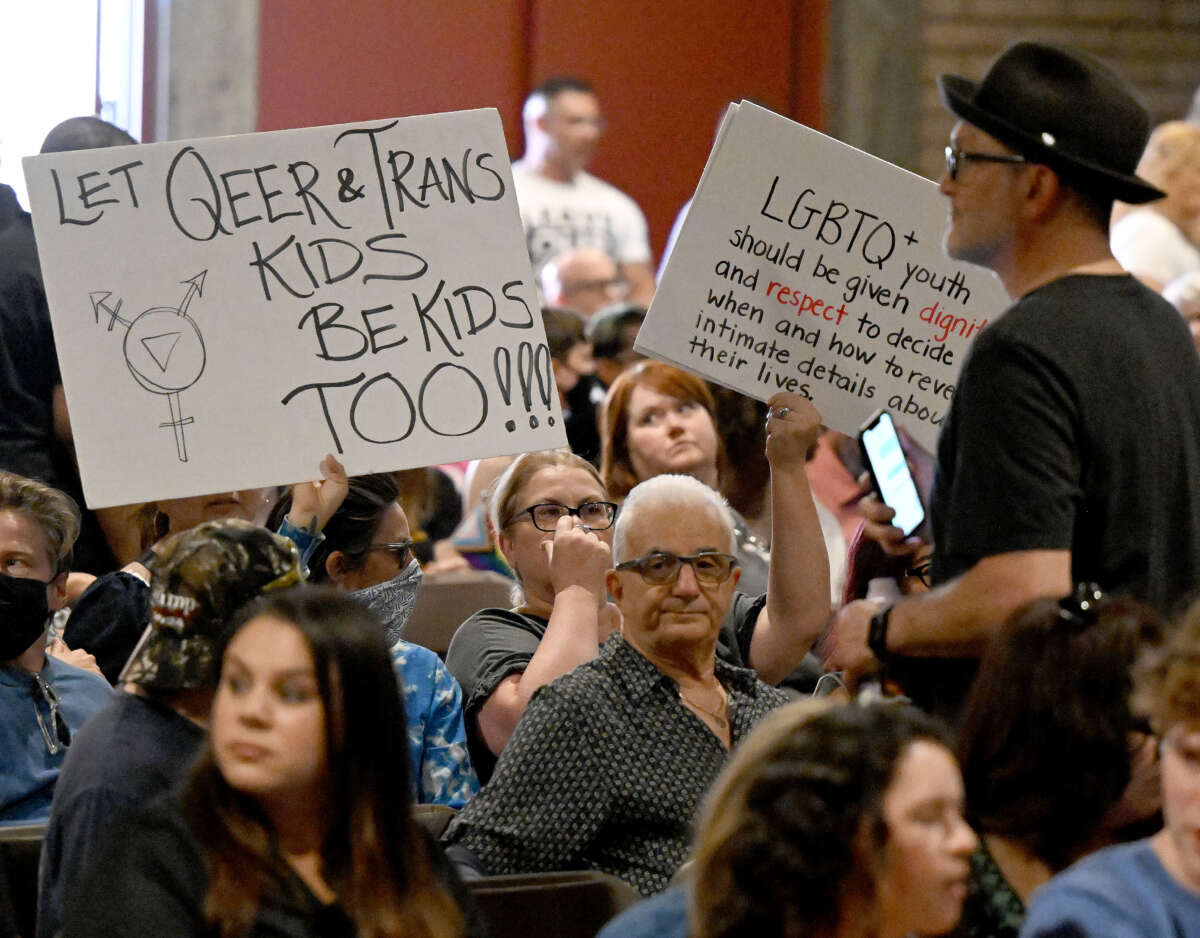 People hold up signs in support of gay and transgender student rights during the Chino Valley Unified School District board meeting at Don Lugo High School in Chino, California, on July 20, 2023.