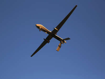 A U.S. Air Force MQ-1B Predator unmanned aerial vehicle (UAV), carrying a Hellfire missile flies over an air base after flying a mission in the Persian Gulf region on January 7, 2016.