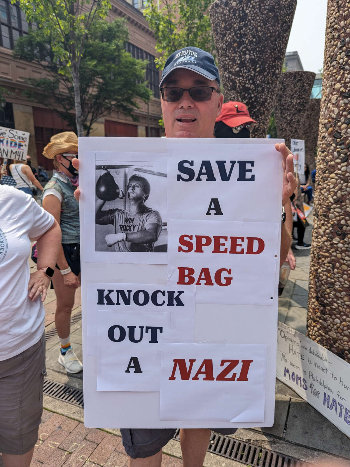A veteran holds a sign that says"Save a speed bag --punch out a Nazi!" at the dance party protest on June 30, 2021.