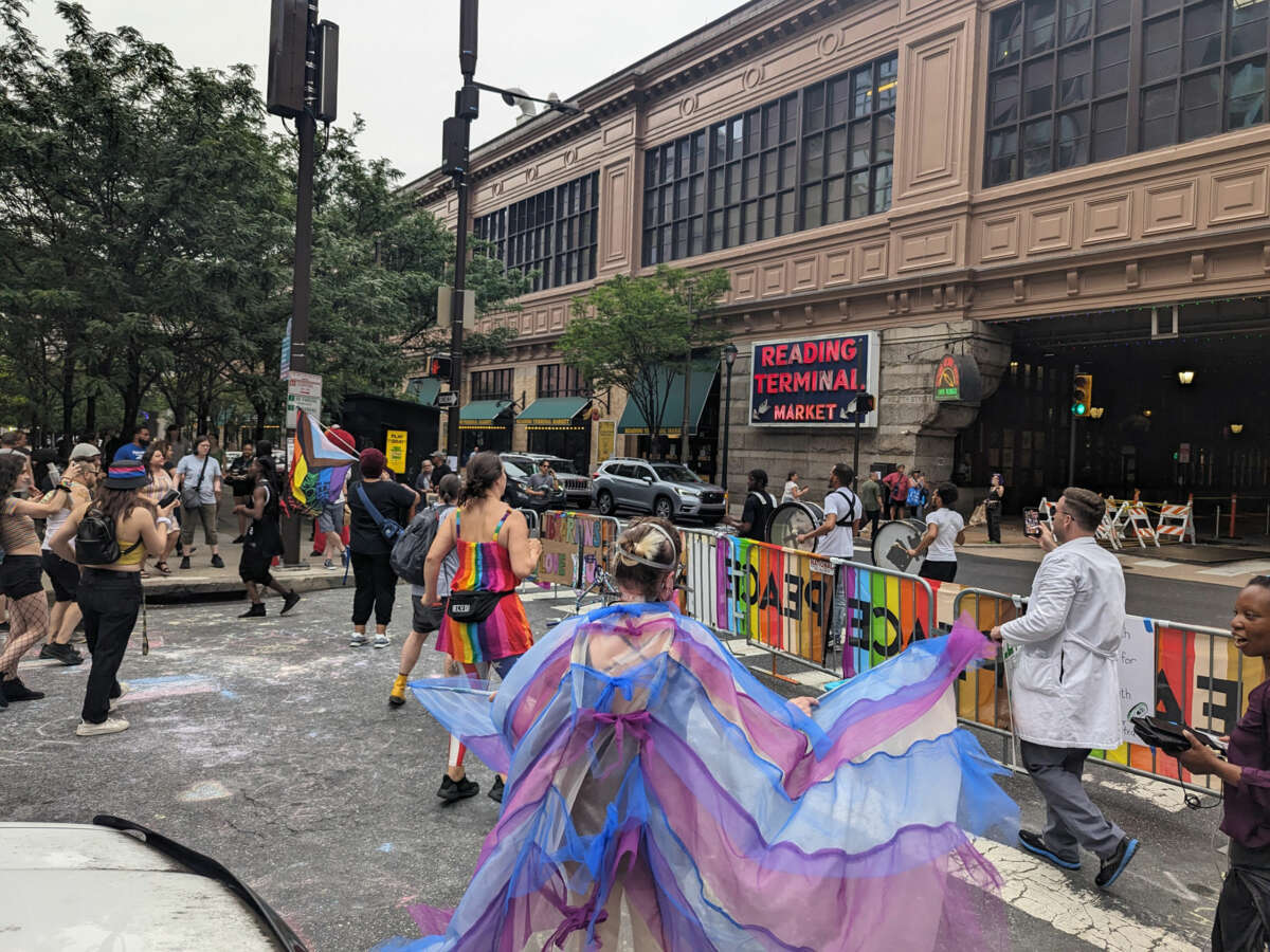 "Philly Elmo" walks past the dance party by the Reading Terminal Market in Philadelphia.