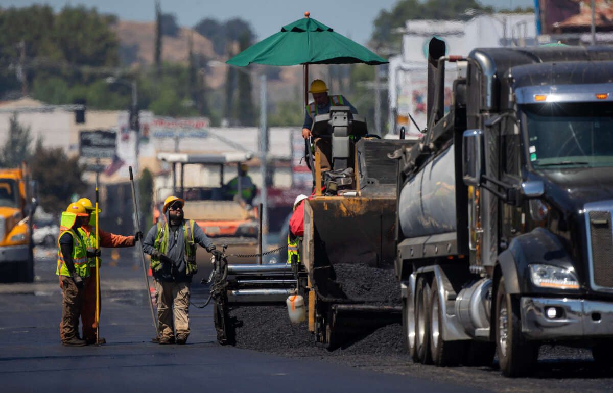 Heat radiates up off fresh asphalt as city street services workers lay down new pavement on Ventura Blvd. on July 27, 2023, in Woodland Hills, California.