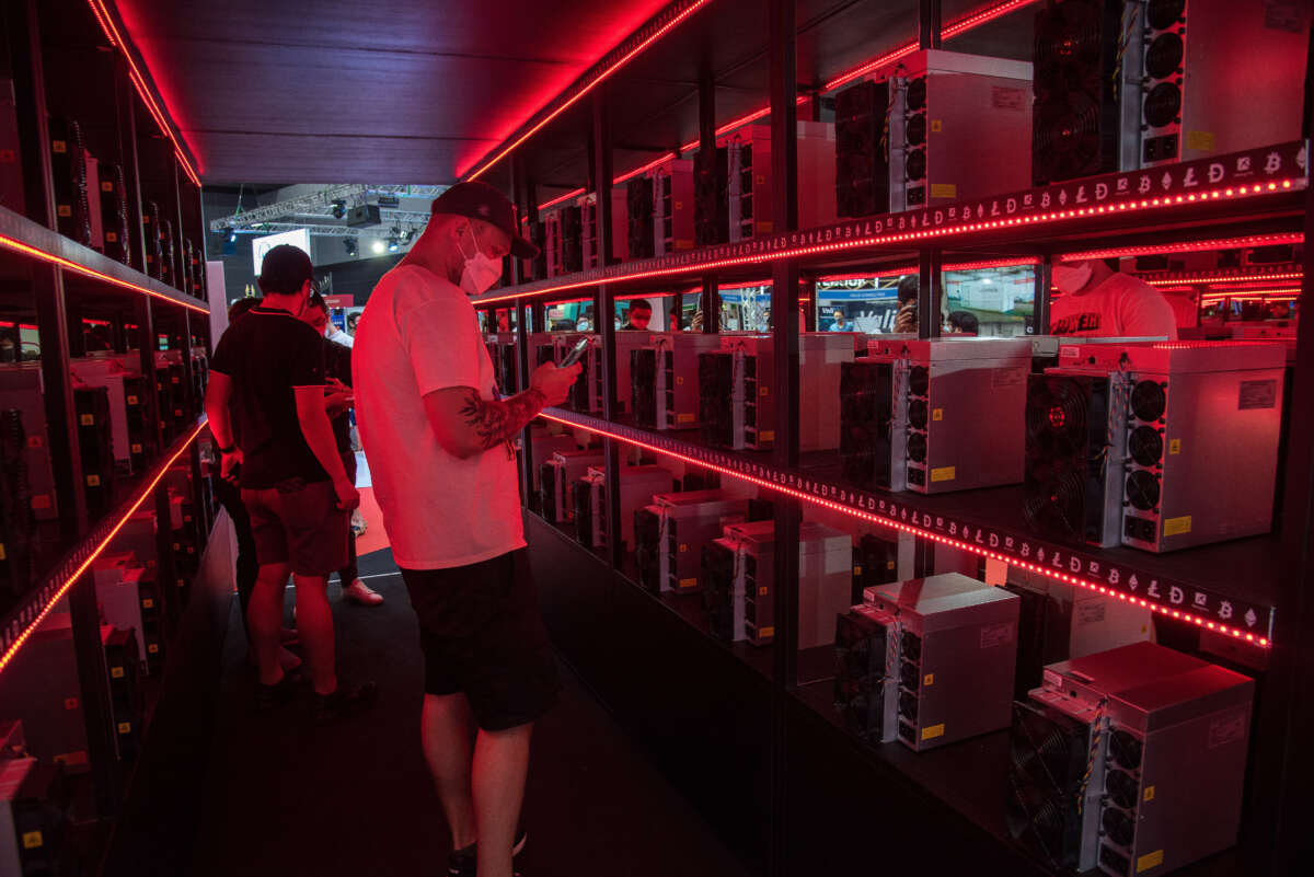 A visitor seen inside a room with crypto miner computers illuminated in red at the MiningPro booth during Thailand Crypto Expo 2022 at Bangkok International Trade & Exhibition Centre (BITEC).